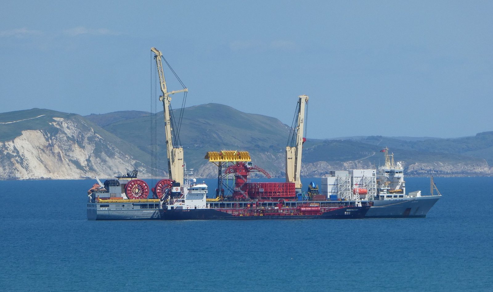 A cargo ship taking on bunker fuel alongside a bunkering tanker