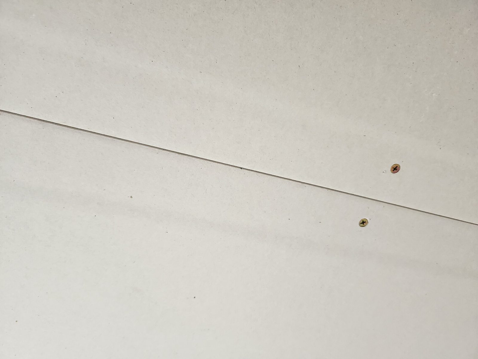 Sheets of gypsum plasterboard stacked with tapered edges visible